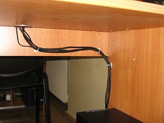 Провода от монитора, клавиатуры и мыши связаны в жгут и закреплены к внутренним поверхностям стола.